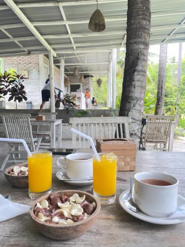 a table with a bowl of food and glasses of orange juice at La Royale Nusa Penida in Nusa Penida