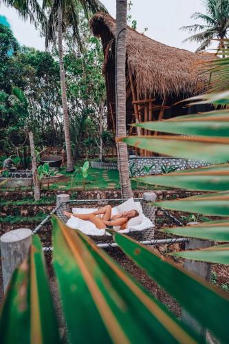a woman laying on a towel in front of a resort at La Royale Nusa Penida in Nusa Penida
