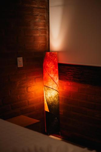 a light in a room with a brick wall at Chale com hidro na Serra da Mantiqueira in Sapucaí-Mirim