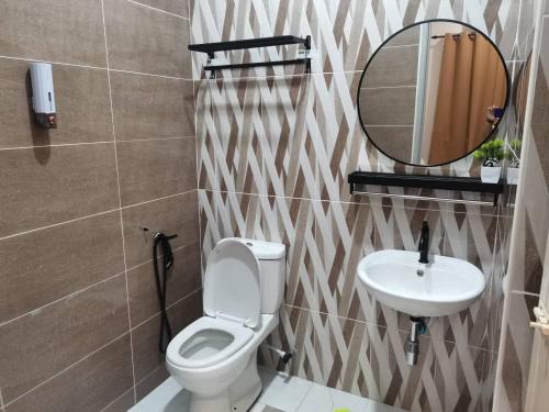 a bathroom with a toilet and a sink and a mirror at Maldira Homestay in Batu Gajah in Gua Sai