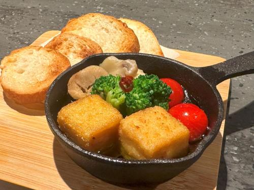 a bowl of vegetables and bread on a cutting board at hotel tou nishinotoin kyoto in Kyoto