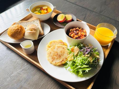 a tray with a plate of food with bread and salad at hotel tou nishinotoin kyoto in Kyoto