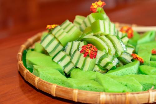 a bowl of green food on a wooden table at Le Palmier Long An Boutique Resort - Free Outdoor Cinema in Ấp Kế Mỹ