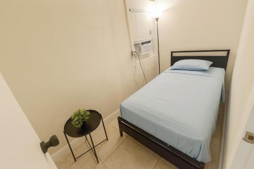 a small bedroom with a bed and a chair at La sama Wynwood in Miami