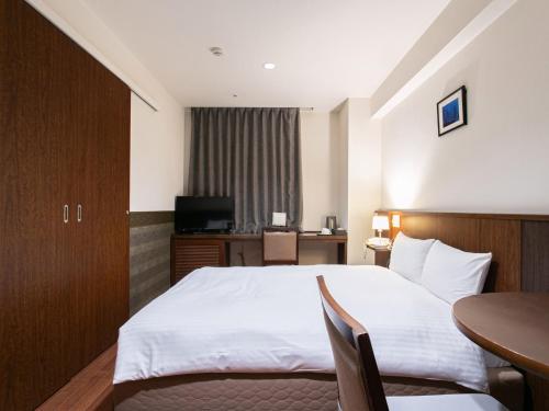 a hotel room with a bed and a table at Sutton Hotel Hakata City in Fukuoka