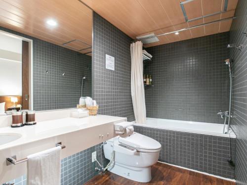 a bathroom with a toilet and a sink and a mirror at Sutton Hotel Hakata City in Fukuoka