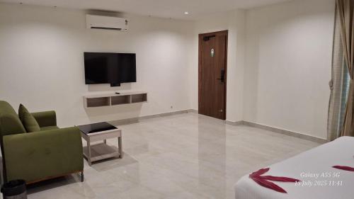 a hotel room with a bed and a television on the wall at Ayana Resorts in Hyderabad