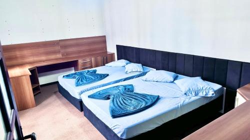 two beds in a room with blue blankets on them at Ampla e luxuosa casa com áreas de lazer in Pelotas