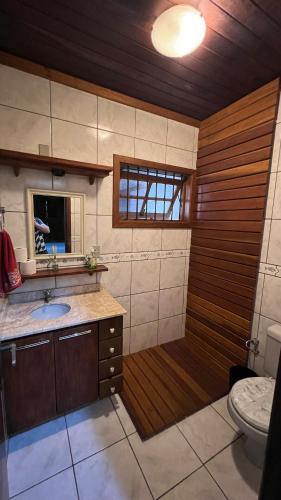 a bathroom with a tub with a sink and a toilet at Ampla e luxuosa casa com áreas de lazer in Pelotas
