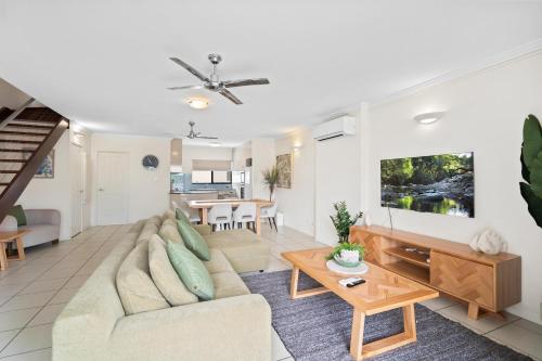 a living room with a couch and a table at Cairns City Apartments in Cairns