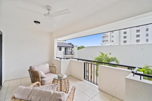 a room with a balcony with a couch and chairs at Cairns City Apartments in Cairns