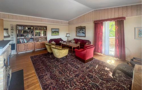 a living room with red chairs and a table at 3 Bedroom Amazing Home In Farsund in Farsund