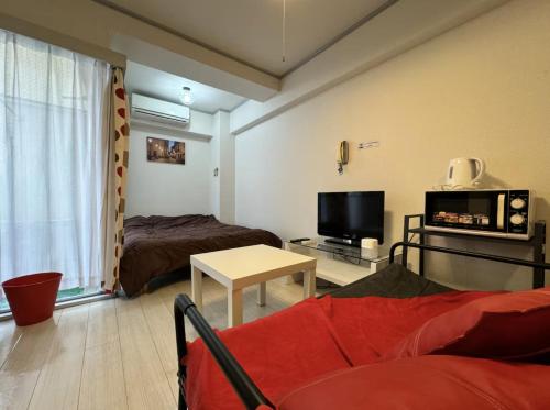 a living room with a couch and a tv at 京橋プルトンビル in Osaka