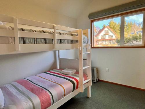 a bedroom with two bunk beds and a window at Smithy's - Lake Tekapo in Lake Tekapo
