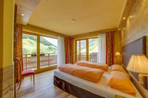 a bedroom with a bed and a balcony at Ferienwohnung & Spa Access Zimmerhofer in Cadipietra