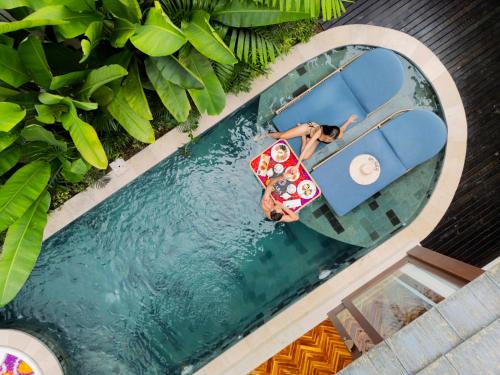 an overhead view of a woman in a raft in a pool at Asvara Resort & Spa Ubud by Ini Vie Hospitality in Ubud