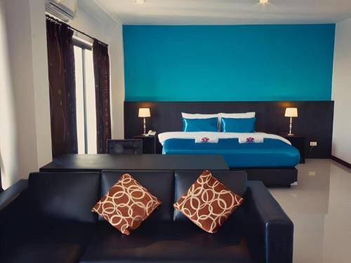 una habitación de hotel con una cama y un sofá en Chada Veranda Hotel, en Ban Si Than
