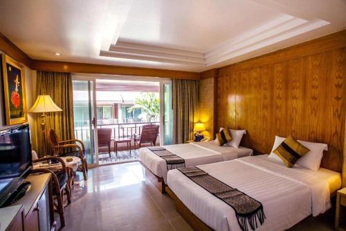 a hotel room with two beds and a television at Phi Phi Banyan Villa in Phi Phi Don