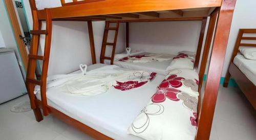 two bunk beds with clothes and shoes on them at Palm Grove Saud Holiday Complex Hotel in Laoag