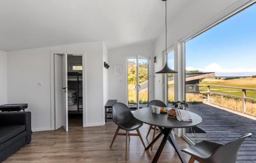 a living room with a table and chairs at Cozy Home In Sejerø With Wifi in Sejerby