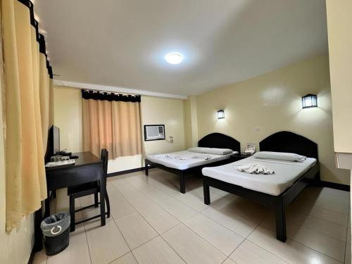 a hospital room with two beds and a desk at Sampaguita Suites Plaza Garcia in Adlawon