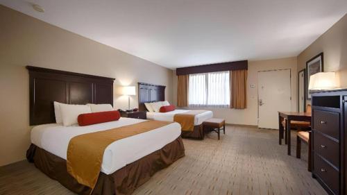 a hotel room with two beds and a desk at Best Western Frontier Motel in Lone Pine