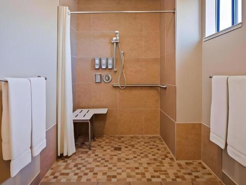 a bathroom with a shower with a bench in it at Best Western Frontier Motel in Lone Pine