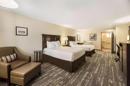 a hotel room with two beds and a chair at Best Western Frontier Motel in Lone Pine