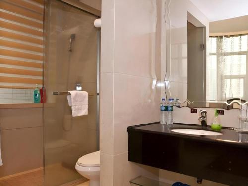 a bathroom with a toilet and a sink and a shower at Fuzhou Xin Zi Yang Hotel in Fuzhou