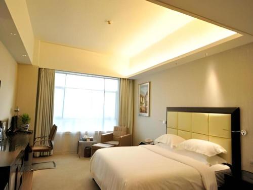 a bedroom with a large bed and a living room at Fuzhou Xin Zi Yang Hotel in Fuzhou