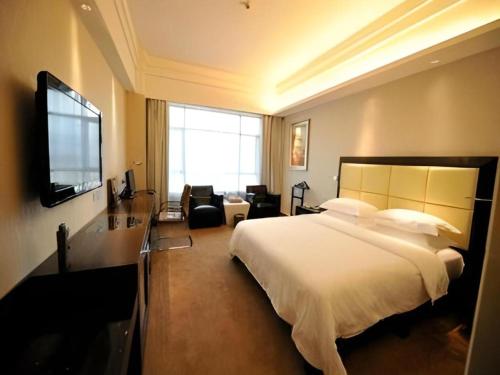 a hotel room with a bed and a television at Fuzhou Xin Zi Yang Hotel in Fuzhou