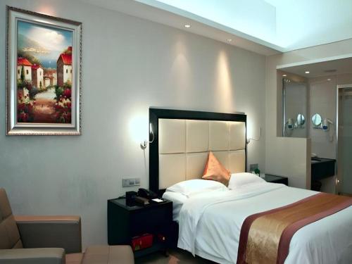 a hotel room with a bed and a picture on the wall at Fuzhou Xin Zi Yang Hotel in Fuzhou