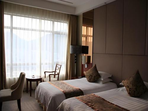 a hotel room with two beds and a window at New Century Hangzhou Qiandao Lake Longting Hotel in Thousand Island Lake