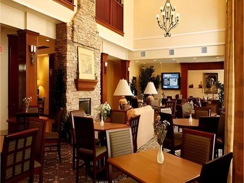 a restaurant with tables and chairs in a restaurant at Staybridge Suites Newport News in Newport News