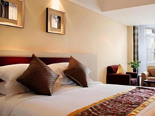 a hotel room with a bed with two pillows at Best Western Tianjin Juchuan Hotel in Binhai