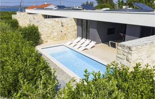 a house with a swimming pool and two lounge chairs at Villa K4 in Zadar