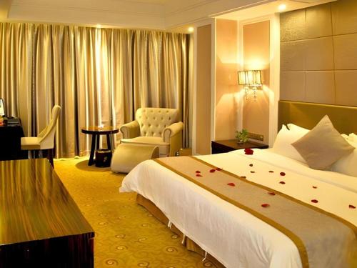 a hotel room with a bed and a chair at Quanzhou Binhai Hotel in Quanzhou