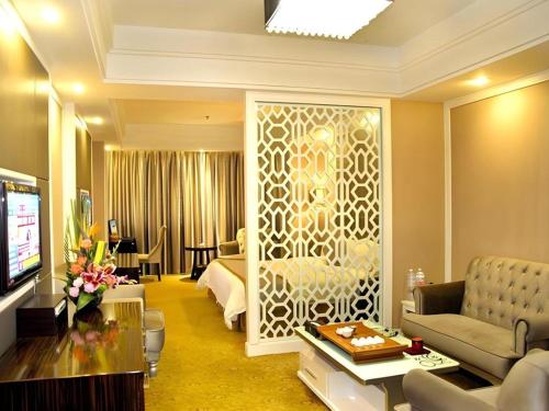 a hotel room with a bed and a living room at Quanzhou Binhai Hotel in Quanzhou
