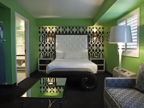 a bedroom with a bed and a couch and a table at Cabana Suites at El Cortez in Las Vegas
