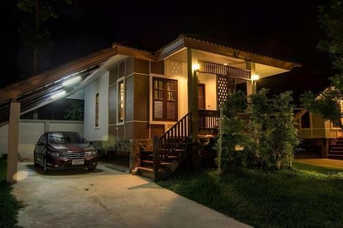 a car parked in front of a house at night at Tong Hotel in Maha Sarakham