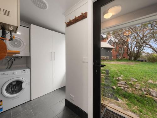a laundry room with a washing machine and a window at SKI View 4 in Mount Buller