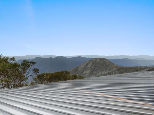 a large metal building with mountains in the background at SKI View 4 in Mount Buller