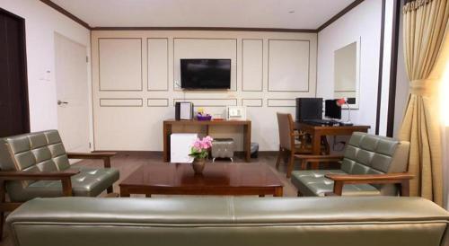 a living room with a couch and a table and a tv at Horizon Hotel in Olongapo