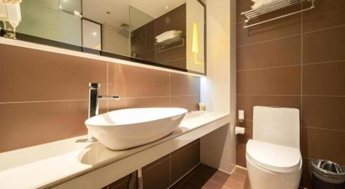 a bathroom with a sink and a toilet at IU Hotel Shanghai Jiaotong University Jiangchuan Road Metro Station in Shanghai