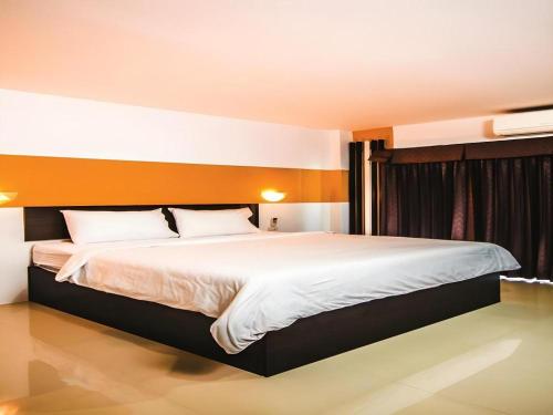 a bedroom with a large bed with white sheets at Mukdaview Hotel in Mukdahan