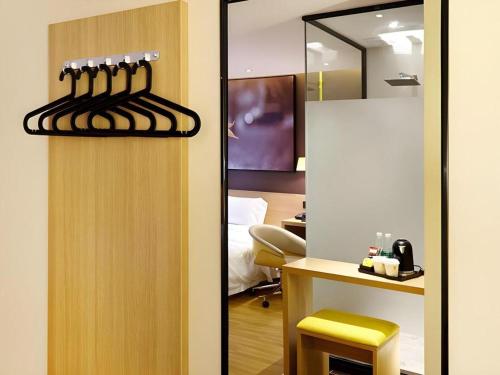 a room with a desk and a door with a mirror at 7 Days Premium Dezhou Qingyun Nanhuan Building Materials Market in Dezhou