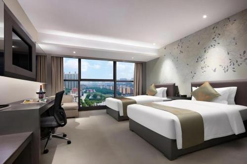 a hotel room with two beds and a desk and a computer at Yongzhou Chuang Fa Cheng XiaoXiangYi Hotel in Guzhuting