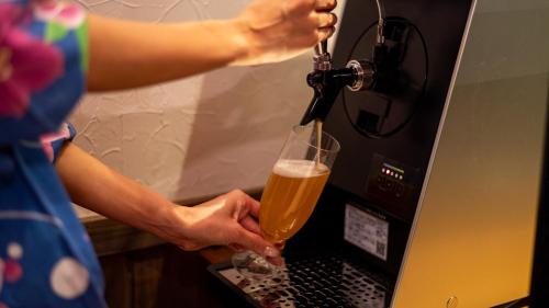 a person is holding a glass of beer at Kaze no Tani no Iori in Gamagori
