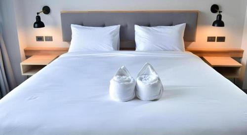 two white shoes sitting on top of a bed at @Sleep in Nakhon Pathom