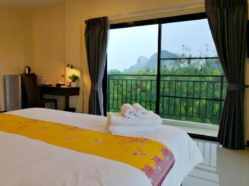 a bedroom with a bed and a large window at The Nest Krabi Hotel in Ao Nang Beach